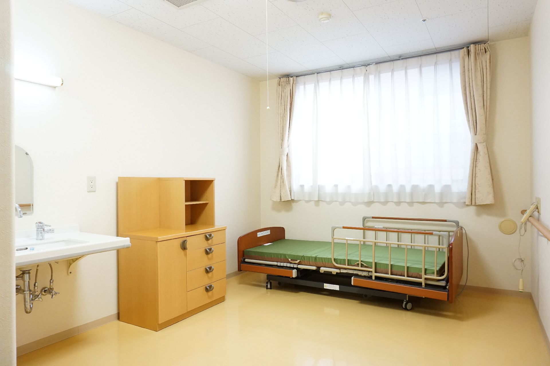 洗面台やチェスト、ベッドが配置された居室