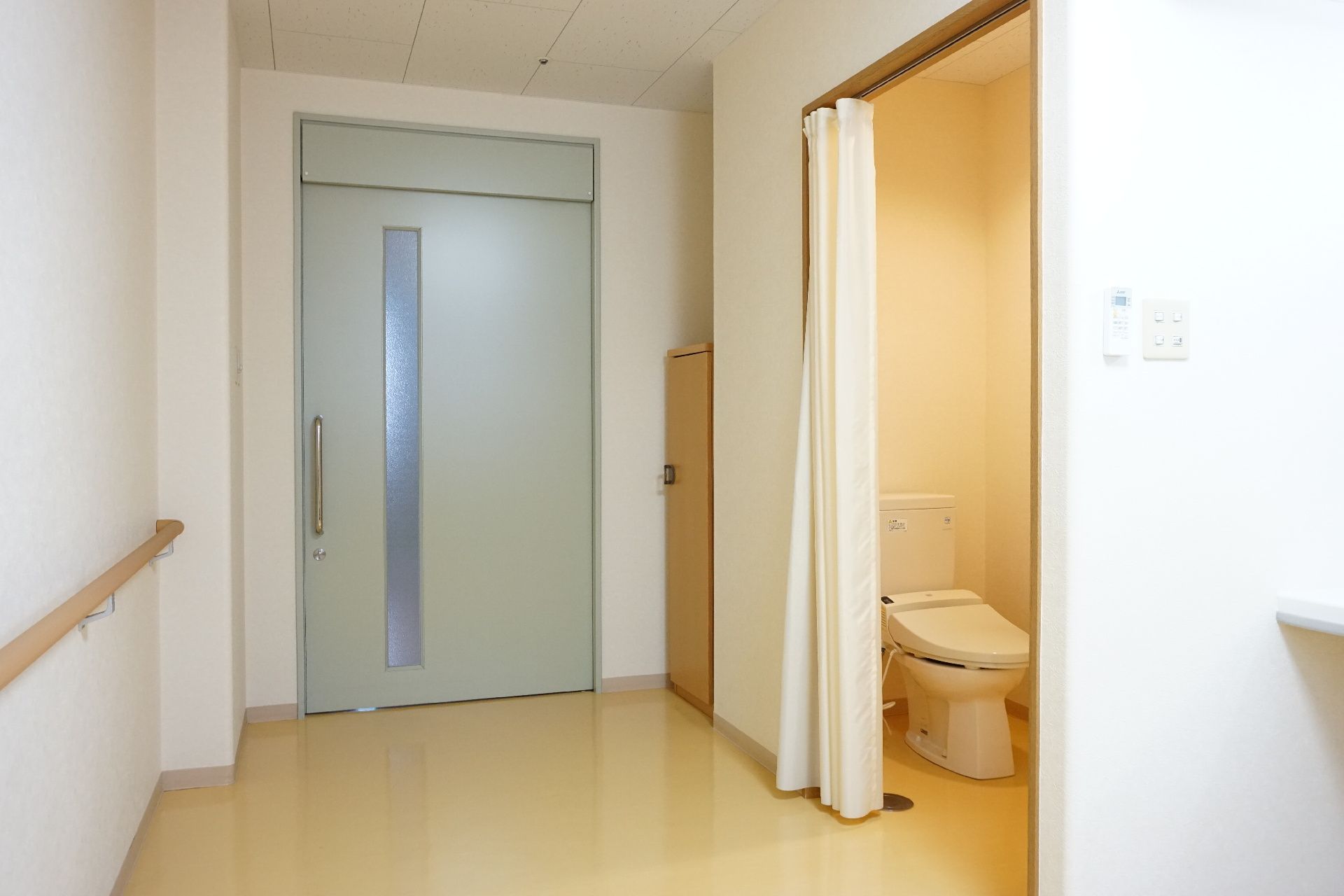 カーテンで仕切られたトイレが設置された居室