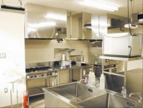 銀色のアルミ製の棚に囲まれた、本格的なキッチンスペース