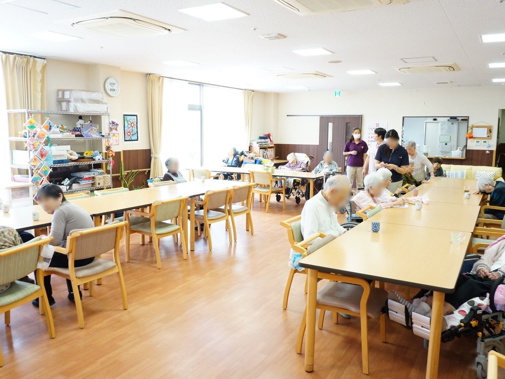 食堂の床は、ナチュラル系の木材が使われている。テーブルと椅子も色が合わせられている。窓から光がたくさん差し込んでいる。