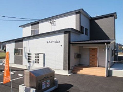 入口に低い三段の階段が設置されている、一軒家のような造りの施設