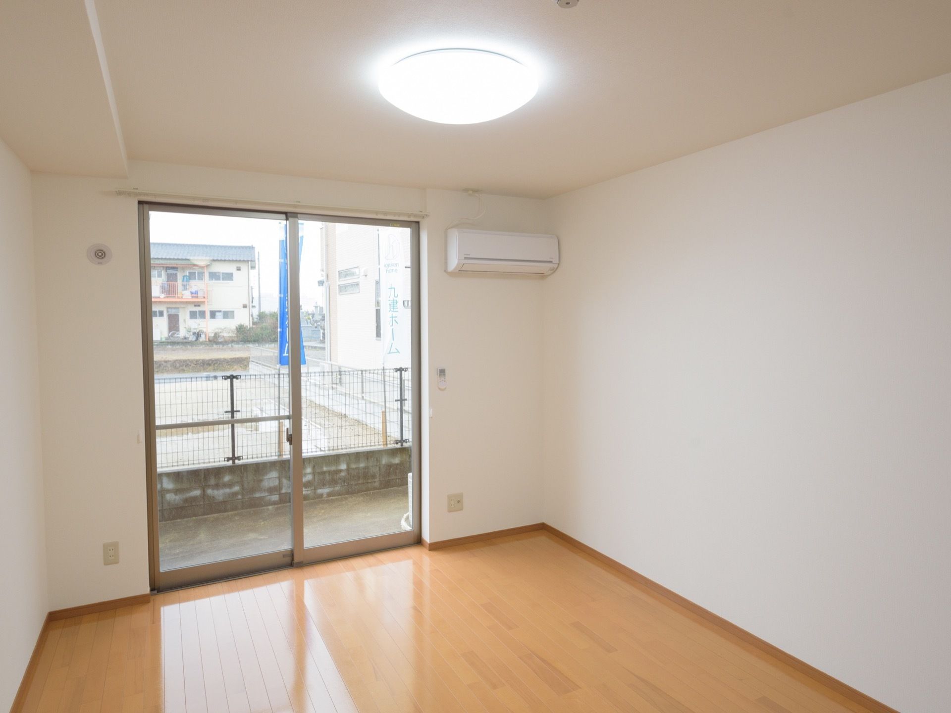 白を基調とした清潔感のある居室には、LEDライト、エアコン、カーテンが完備され、床は木目のきれいなフローリングである。