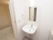 真っ白で小さめの洗面スペースがトイレ内にある。隣には浴室があり最新式のユニットバスが備えられている。