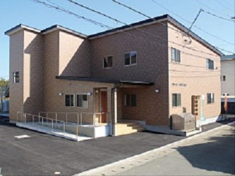 レンガ調の外壁を採用したおしゃれな外観。道路から入り口まで段差がなく、アプローチには手すりが設置してある。