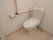 居室には清潔感のある洋式トイレがあり、右手の壁にはＬ字型の手すりとペーパーホルダーが取り付けてある。
