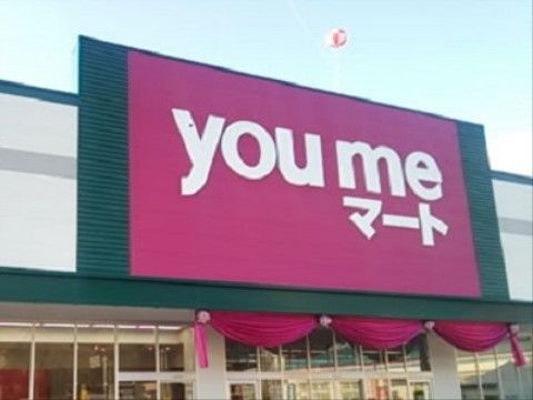 スーパーの名前が書かれた大きな赤い看板がある。施設の近くには、大きなスーパーがあり食料品などが買える。