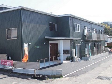 玄関の横に手すり付きのスロープが設置されている施設の外観