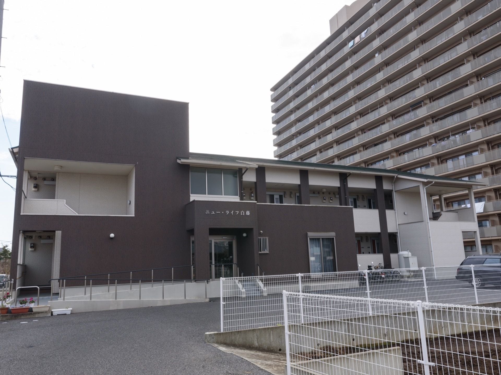 ダークブラウンを基調としたスタイリッシュな雰囲気の施設は2階建てで建てられており、建物の前には駐車場が完備している。