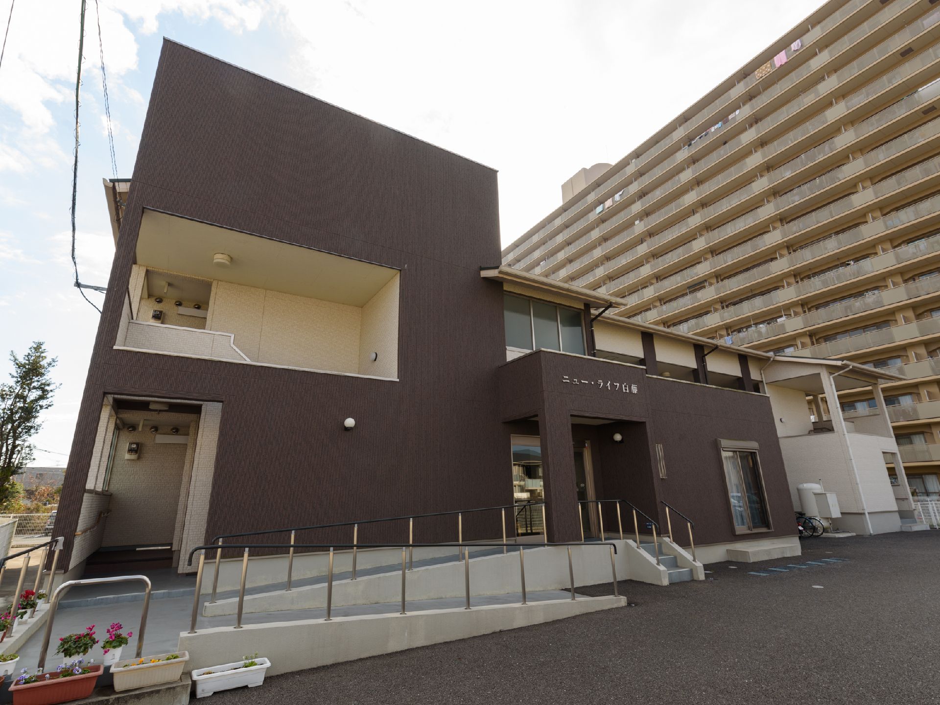 手すり付きの低い階段やスロープが建物の前にある施設外観