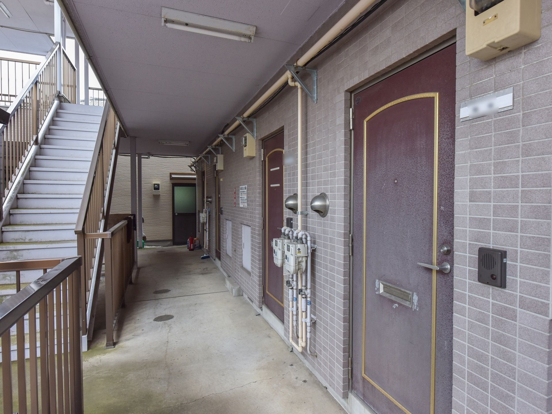 各部屋の玄関扉はボルドー色で落ち着いた雰囲気になっており、扉の横には表札がつけられている。床はコンクリートでバリアフリーになっている。