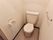 トイレには洋式便器が設置されている。座って右側にトイレットペーパーフォルダー、左側にタオルハンガーがつけられている。