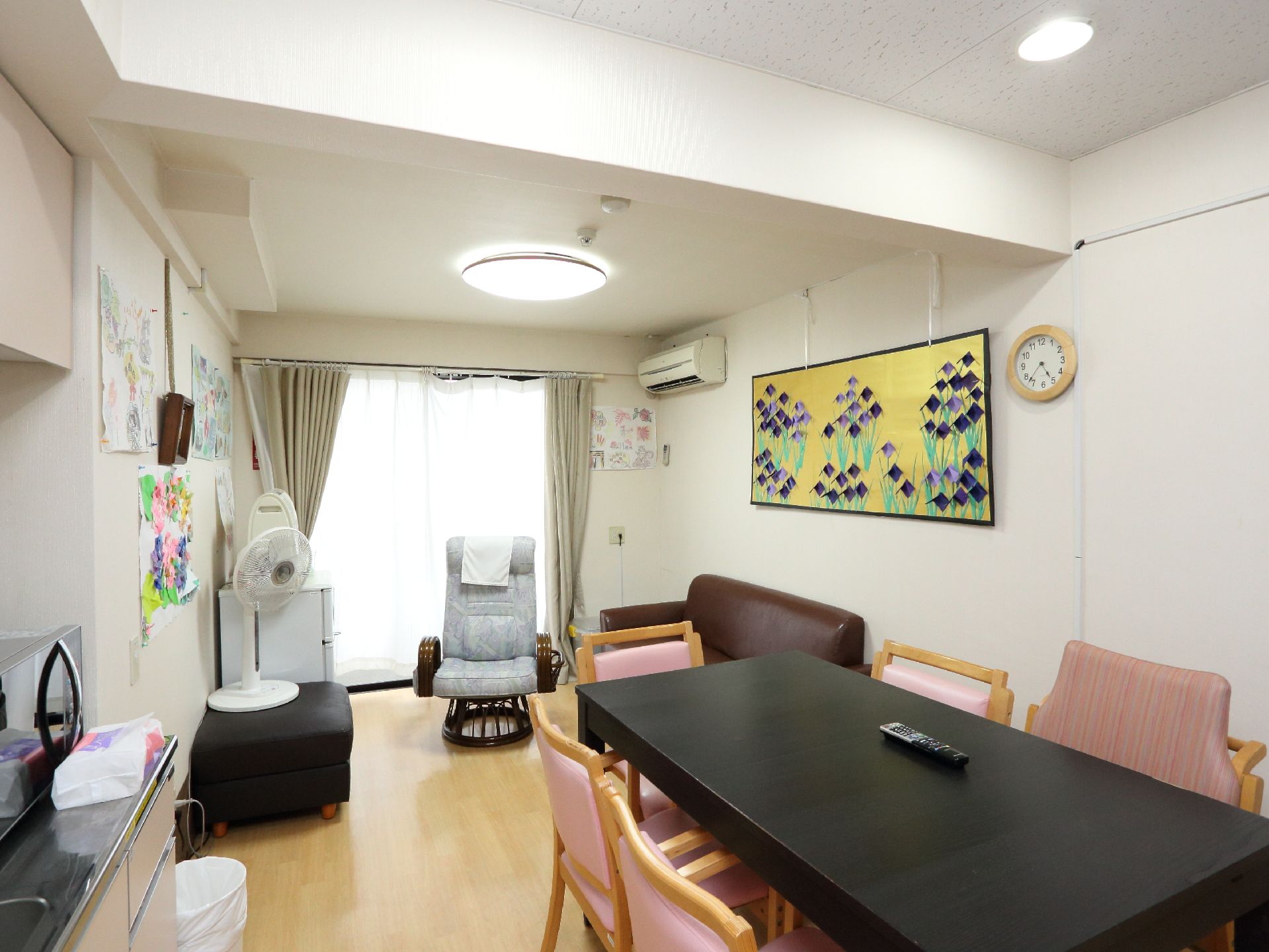 複数の入居者が談笑したり趣味に興じたりできる部屋。窓のすぐ右側の壁にはエアコンが取り付けられている。