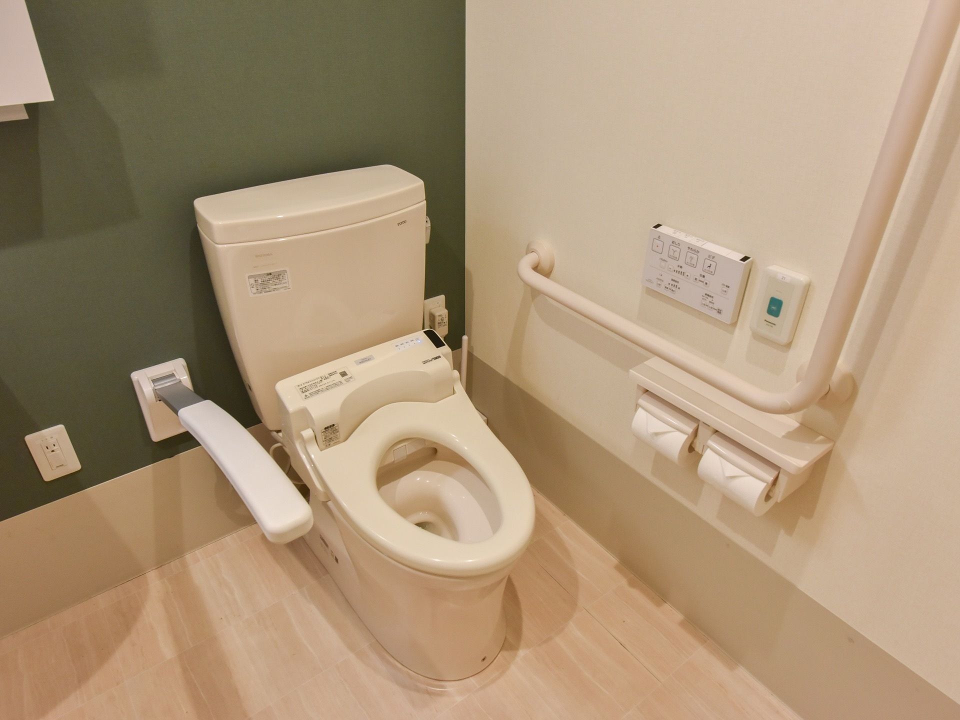 便座のそばに手すりが備え付けられている。緊急呼び出しボタンや、便座を温める機能がついているので、ご高齢の方でも安心してご利用いただける。