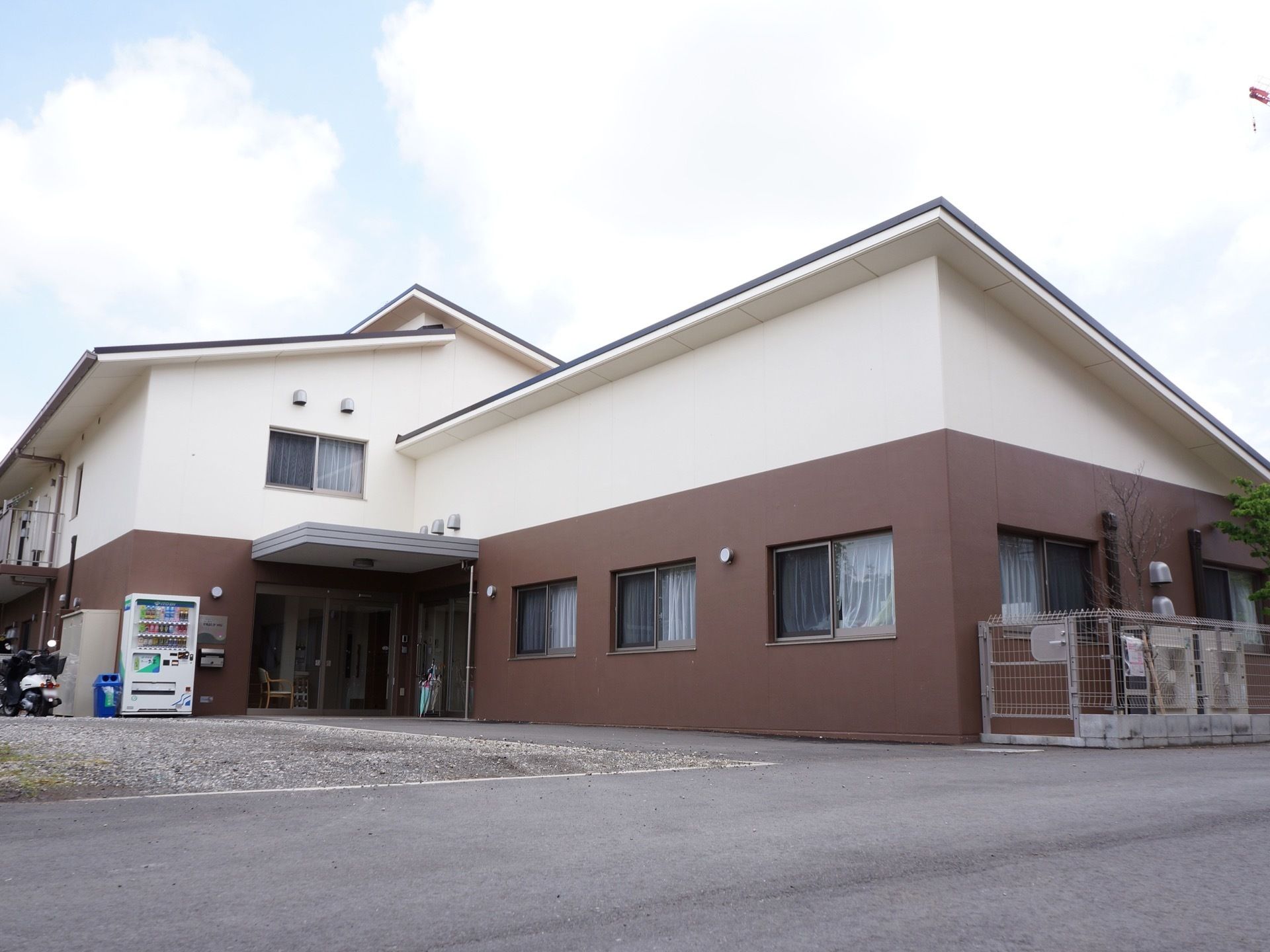 落ち着いた外観の建物で、広めの駐車場がある。入り口には自動販売機を設置してある。窓が多くとても開放的な作りになっている。