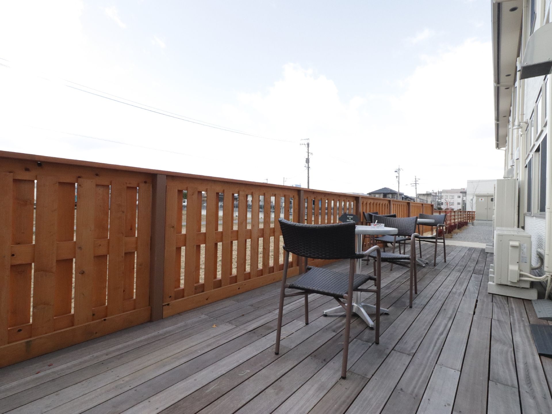 建物の１階の部屋からは外に出て、ベランダにある椅子に腰をかけることができる。程よい高さの木の柵があるので、外からの視線も気にならない。