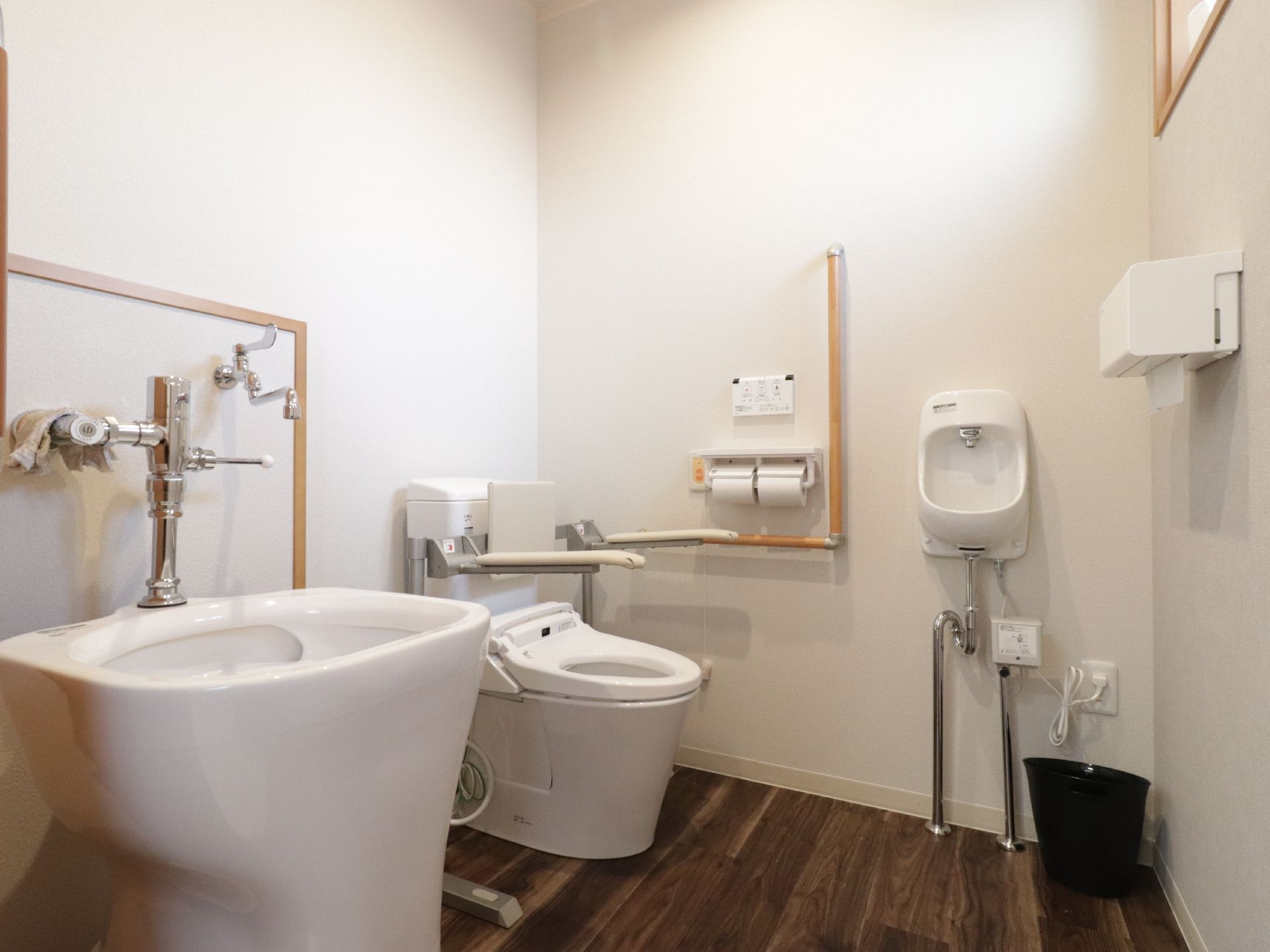 洋式トイレの手すりははね上げ式で、移動の際には邪魔にならなくて便利である。汚物流し便器と洗面台も設置されている。