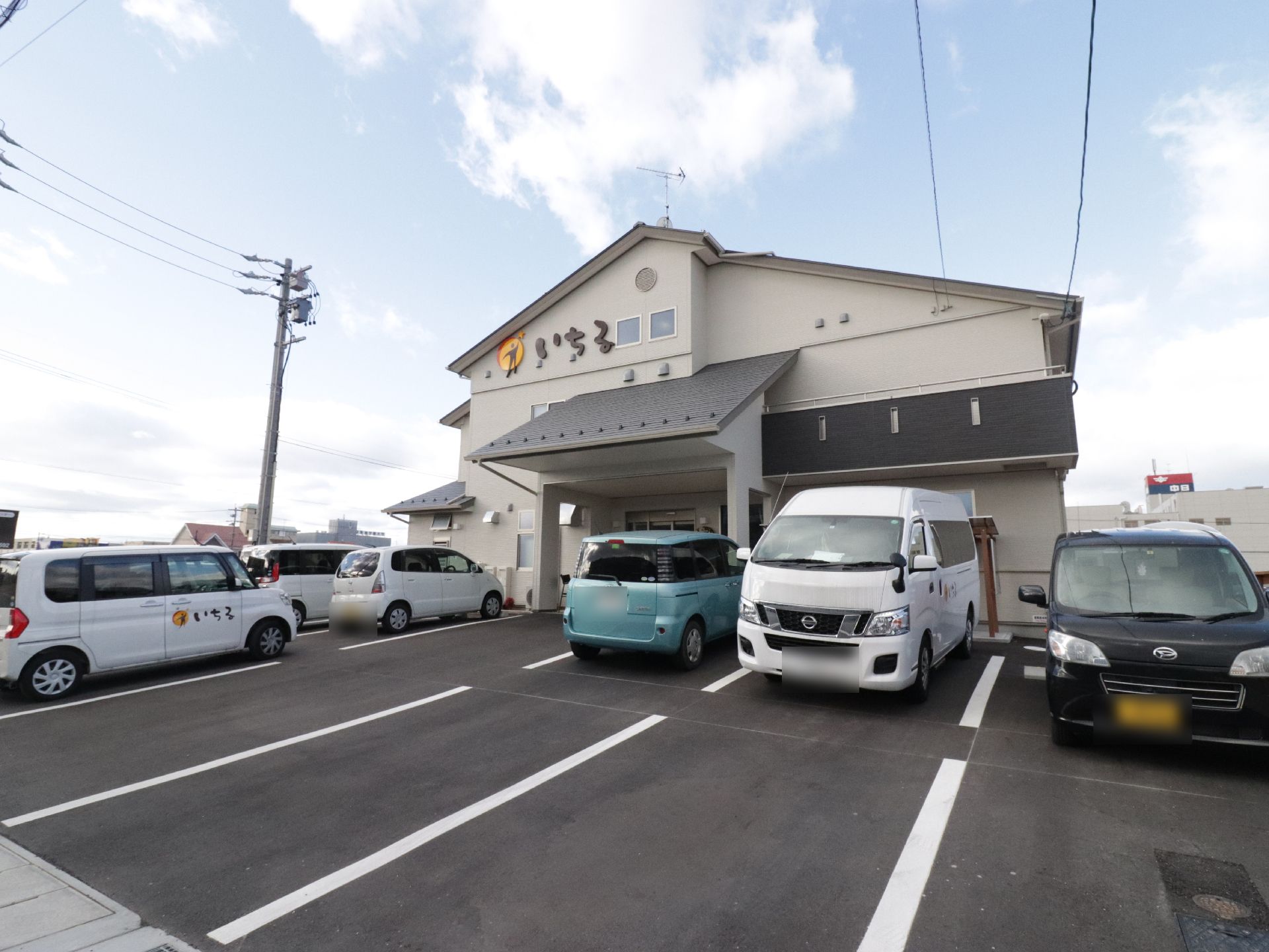 建物の前に十台以上の駐車スペースが完備されている施設の外観