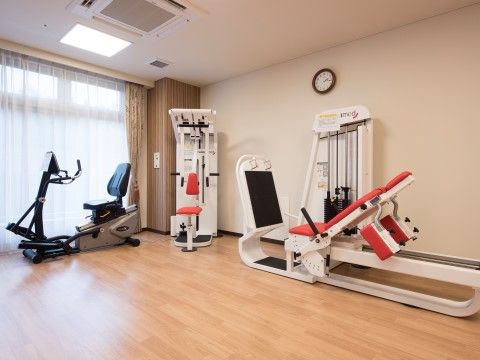 フローリングの室内に、何種類もの機能訓練専用の器具がおかれている。大きな掃き出し窓があり、明るい光が入っている。