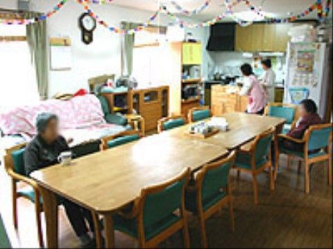 天井に折り紙の飾りが吊るされているスペースに集まっている入居者たち