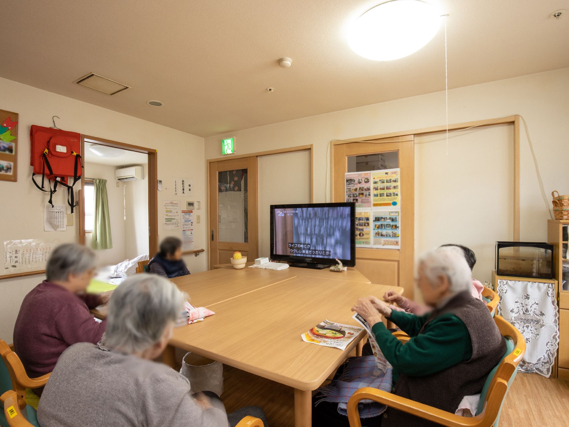 明るく広々とした部屋の中央に大きなテーブルが設置されている。正面にはテレビが置かれ、入居者様が集まってくつろげるようになっている。