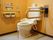 手すりや呼び出しブザーが付いたトイレである。温水洗浄便座も設けられ、機能的にも安全性にも優れている。