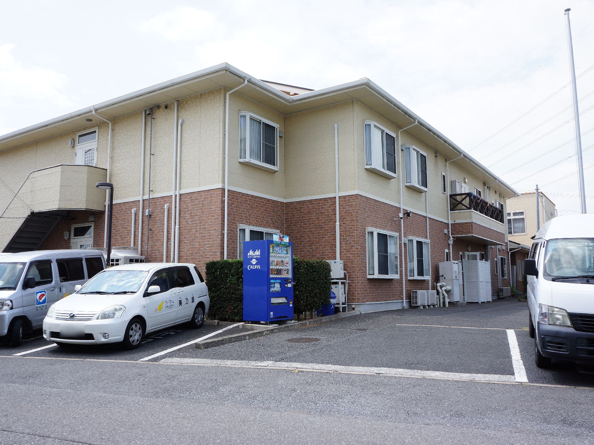 駐車場が設けられている。自動販売機が設置されている。来訪者の駐車スペースにも困らない。非常時に2階から逃げられる階段がある。