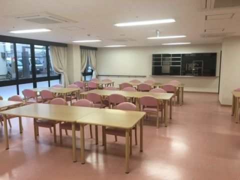 大きな窓からは明るい日の光が注がれており、リビングの雰囲気と調和した色合いのカーテンが留められている。壁には手すりが備え付けられている。