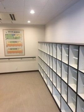 十分な大きさのシューズボックスがあり、来訪者様に余裕をもって対応ができる。正面の壁にはカラフルに識別された施設内の案内図がある。