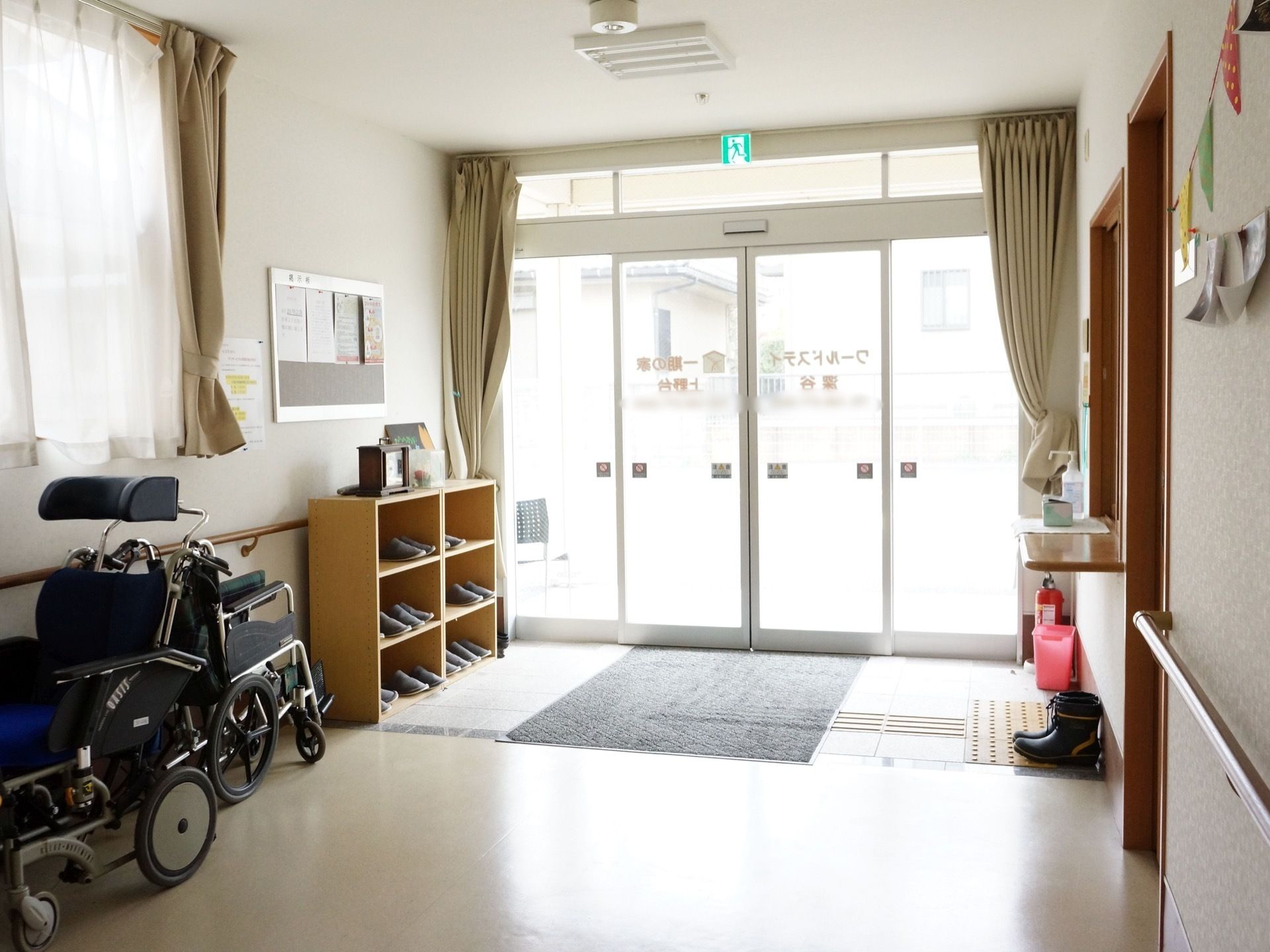 玄関の入口は自動ドアで、ドアには施設の名前が印字されている。玄関の床には大きなマットが敷かれている。