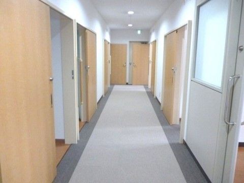 左右に横開きのスライド式ドアが並んでいる施設の廊下