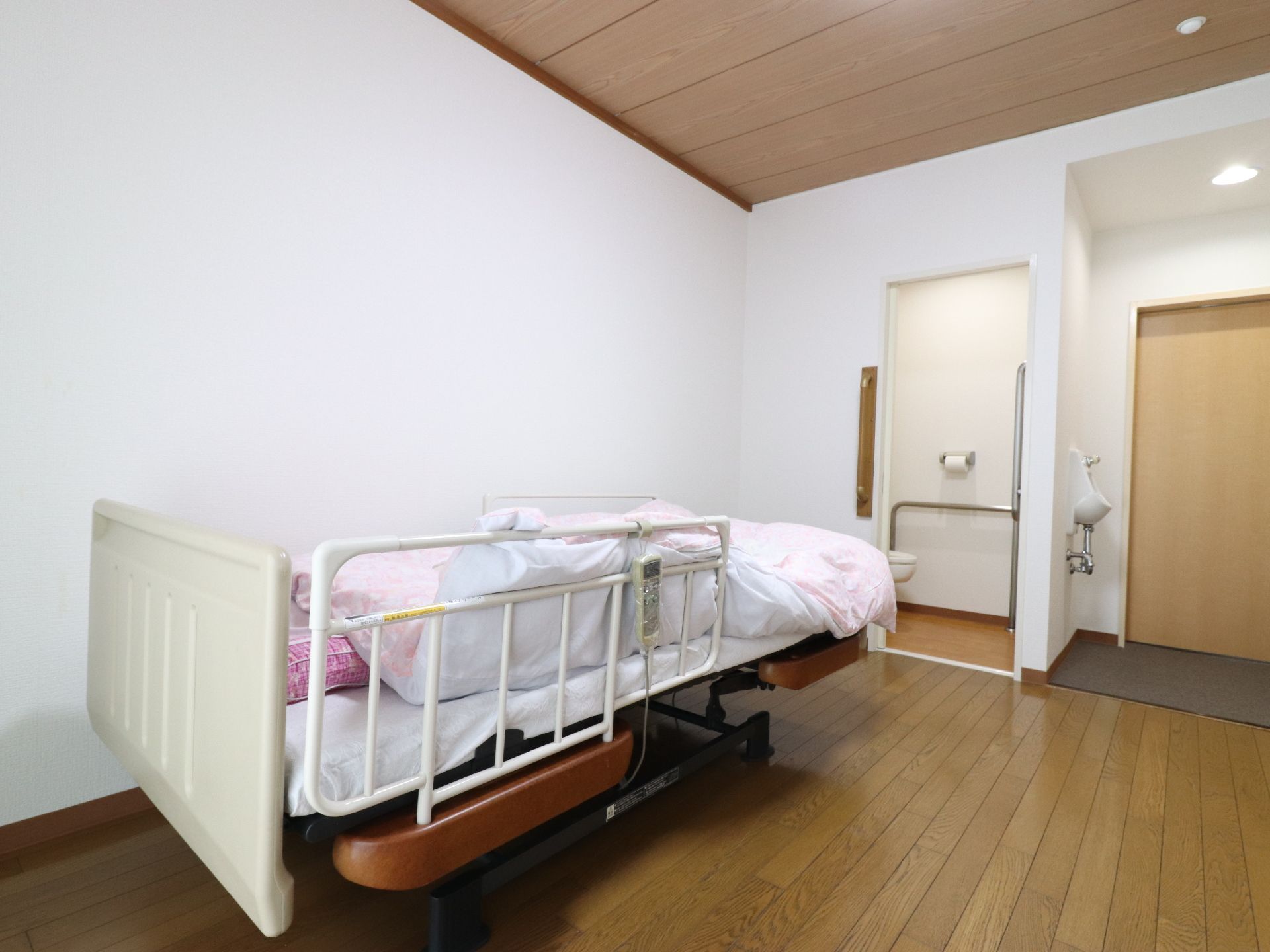 居室には、転落防止の介護用ベッドが置かれている。家具を持ち込むことができるので、自分好みの部屋にできる。
