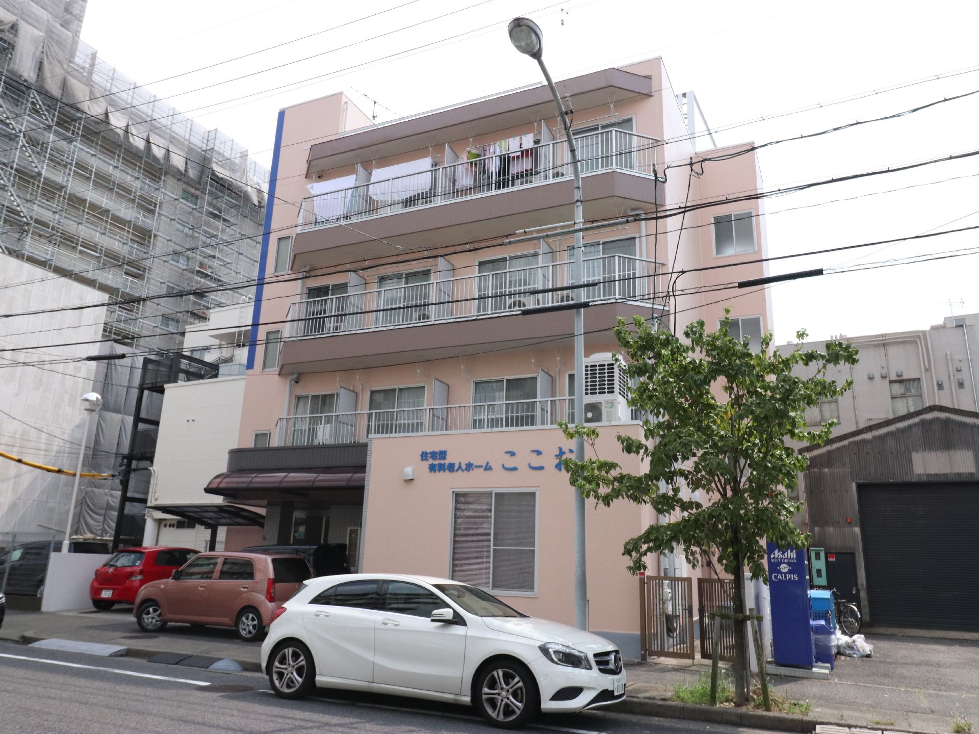 建物は、道路に面した位置にある。側には街路樹もあり、季節を感じることができる。4階建ての建物で、駐車場も完備している。