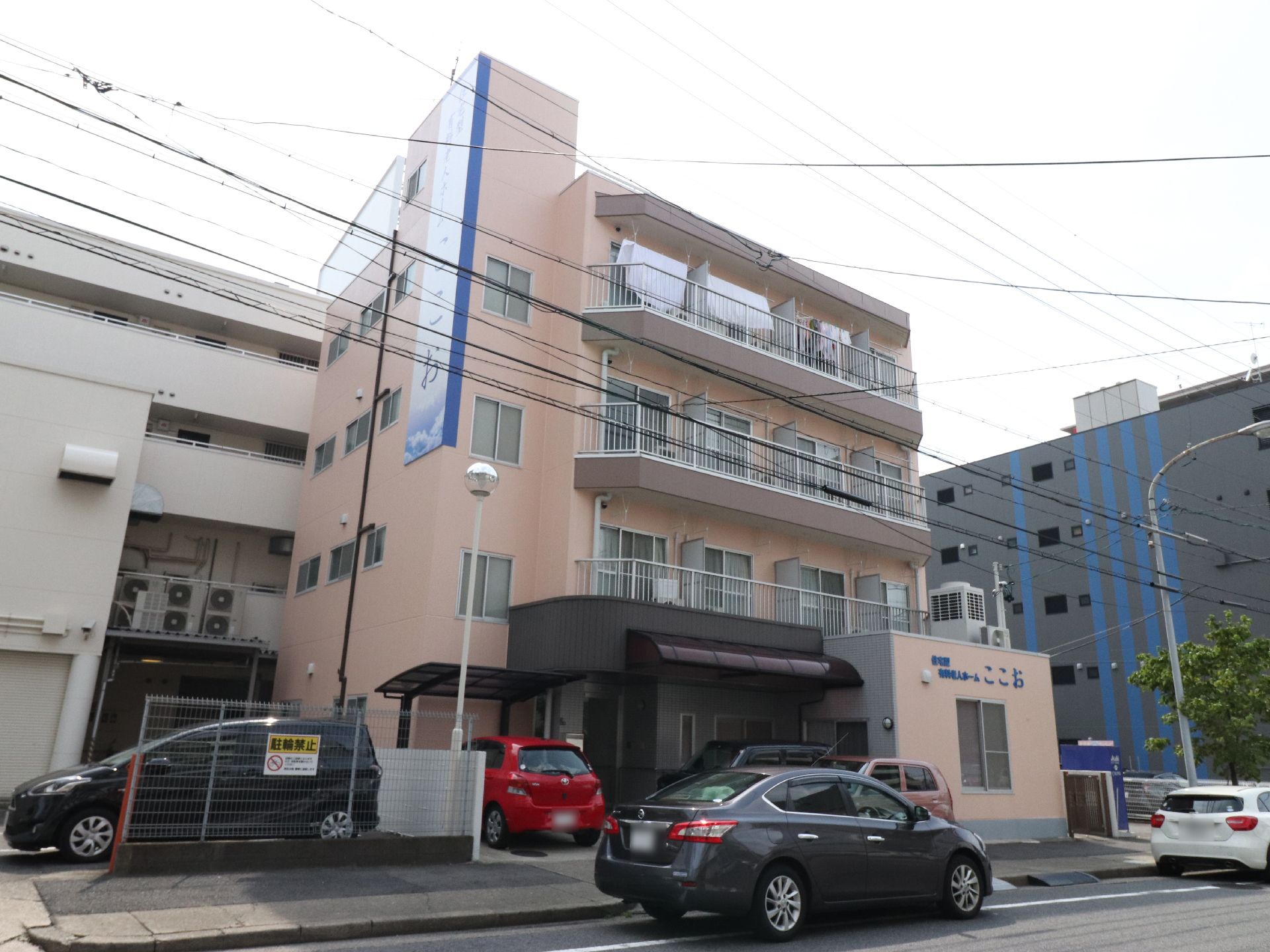 施設の名前が大きく書かれた看板が掲げられている。来訪者は、建物の色と看板を頼りにすると迷わず来られる。