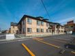 ２階建てで壁がレンガ調になっている。１階部分の壁には給湯器が設置されている。隣との境にはフェンスがある。