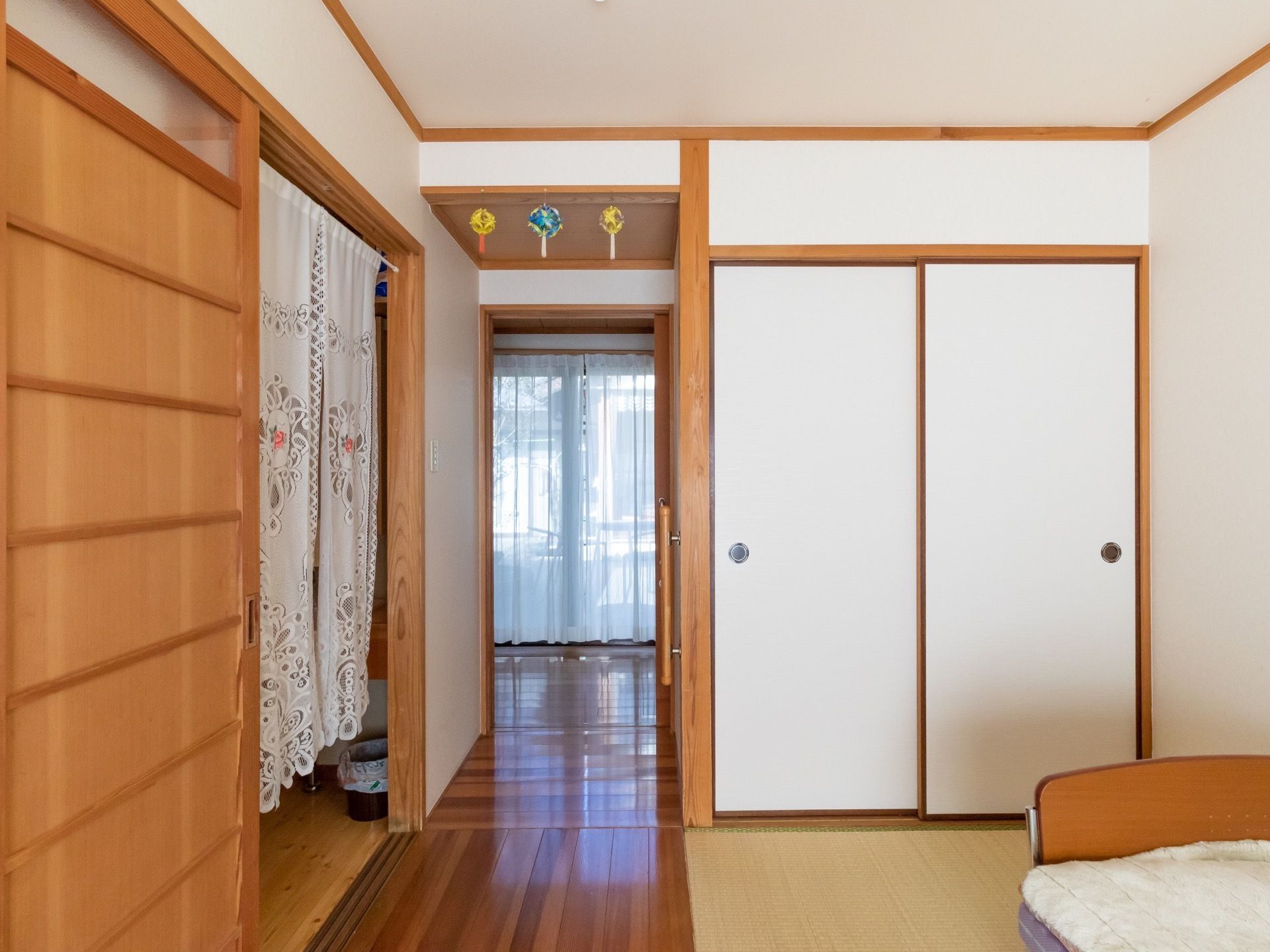 押し入れががある居室で、床の一部に畳が敷かれている。洗面台の入口には、のれんが掛けられている。