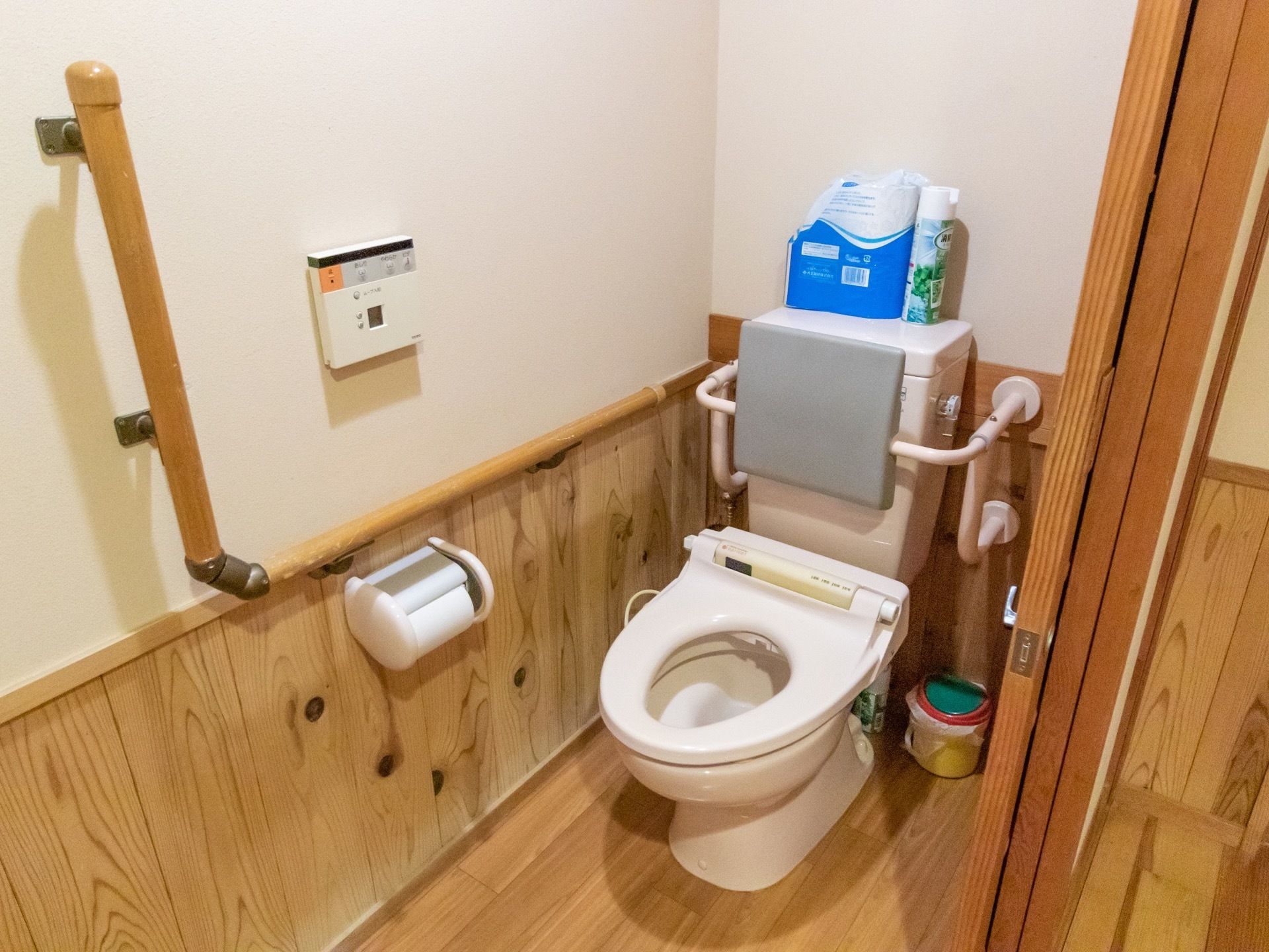 木のぬくもりを感じられる清潔感のあるトイレ。個室内には、予備のトイレットペーパーや消臭スプレーが用意されている。