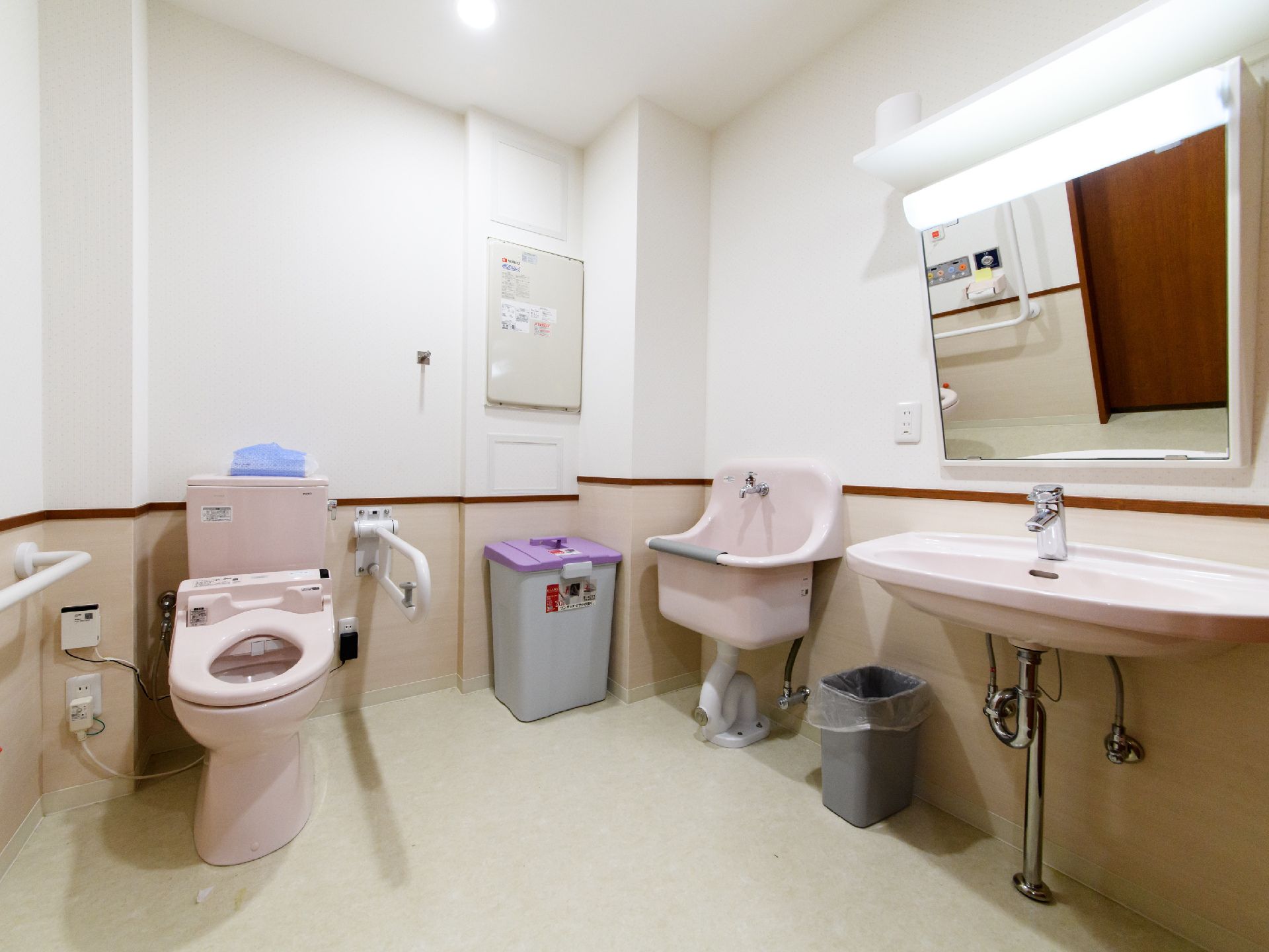 洋式トイレが設置してある。便座の両サイドの手すりが設けてあるので、立ったり座ったりが楽である。鏡、洗面台が付いている。ごみ箱がある。
