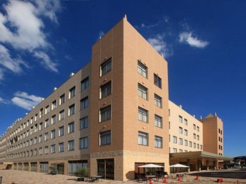 青空の下に建っている、かなり大きな五階建ての施設外観