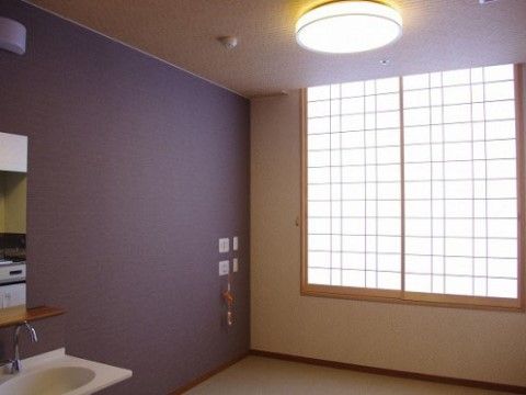 壁に使用された紫色と光を和らげる内障子が慎みある空間を作り上げている。洗面台やナースコールも完備されている。