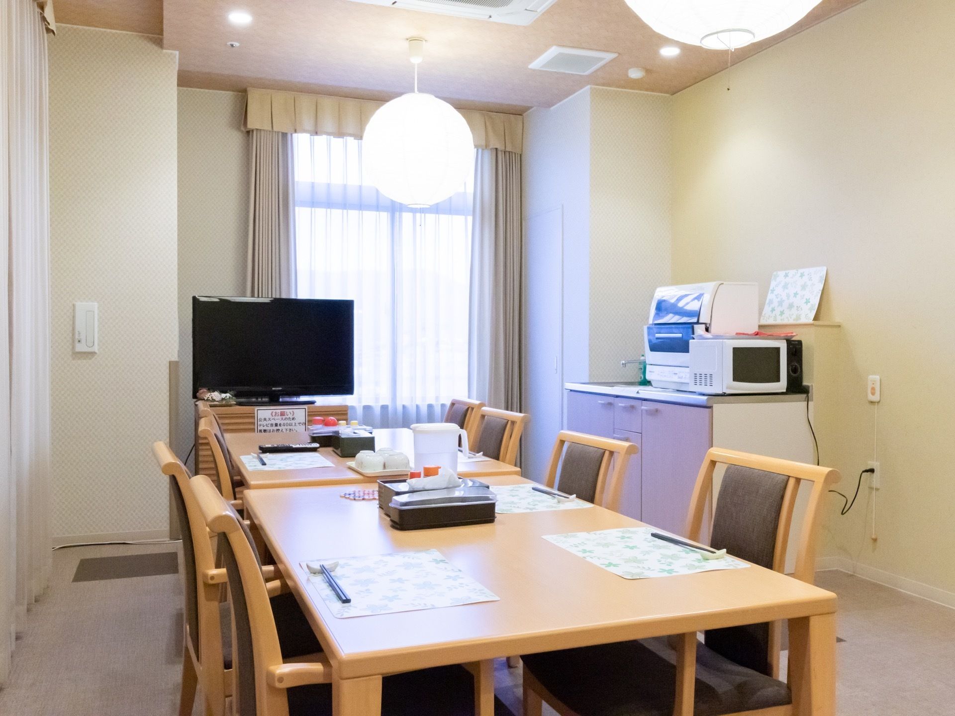 リビングラウンジは２面採光で、日当たりが良く居心地の良い雰囲気。テーブルを中央に配置し、通路を広々と設けている。