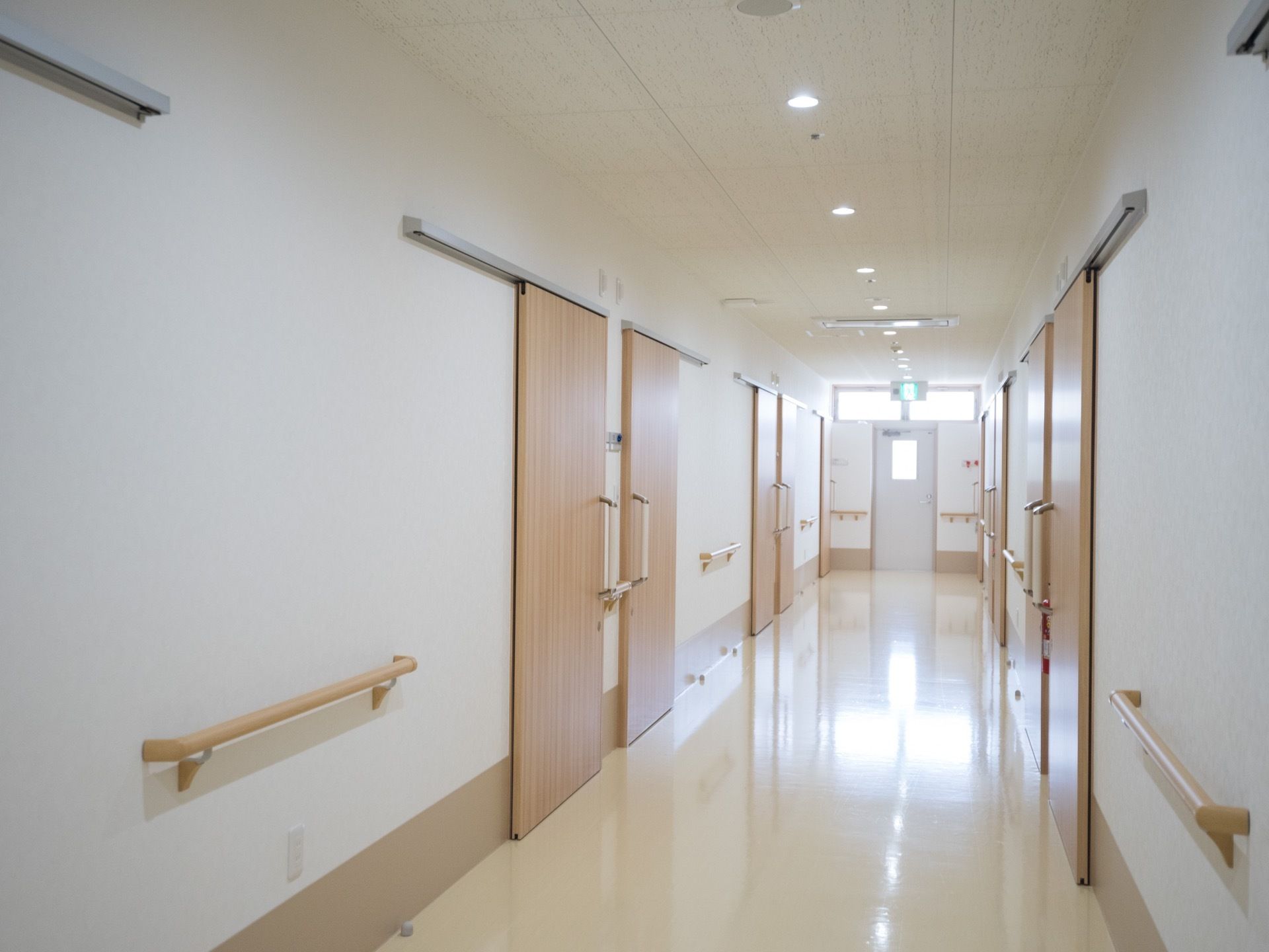 廊下の奥に明かり取りの窓があり、日中は室内に日の光が取り込めるように設計されている。安全のため、壁には手すりが設置されている。