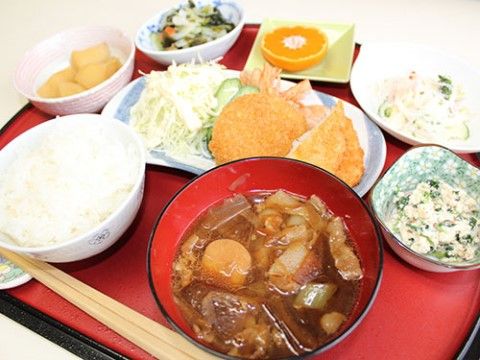 たくさんの具が入っている汁物やフライが並んでいるお膳