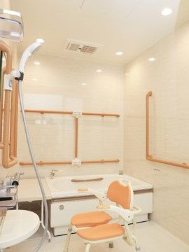 明るく清潔な浴室である。洗い場には、バスチェアーや体勢に合わせて高さを調節できるシャワーホルダーが設置されている。