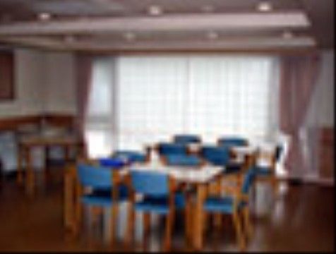 床は段差がないフローリングである。机２台と、青い背もたれがついた椅子が置かれている。レクリエーションにも利用できる。