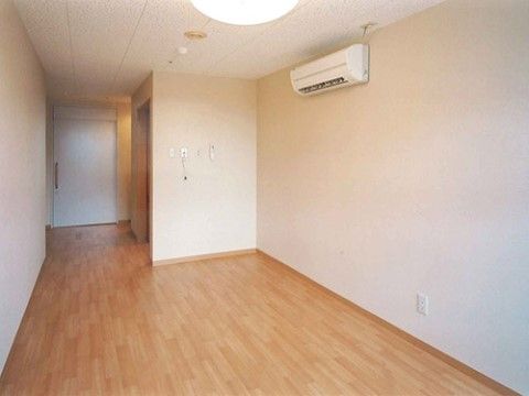 エアコンのみが設置されている、家具が置かれていないフローリングの居室
