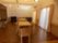 床は寄木のように組み合わせたデザインのフローリングである。部屋には大きな掃き出し窓があり、奥には大型のテレビも置かれている。