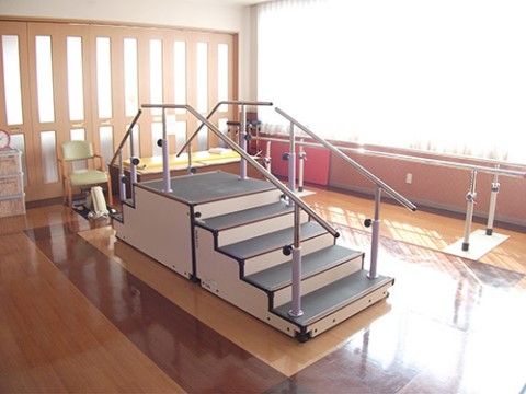 太陽の光がたっぷりと差し込むトレーニングルームである。両サイドに手すりが付いたリハビリ用の階段や、平行棒が用意されている。
