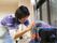 聴診器を首から吊るしたスタッフが、入居者の様子をうかがっている風景