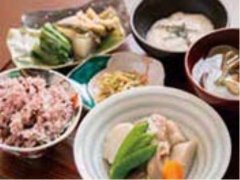 煮物や赤飯、吸い物に野菜の和え物などが並んだ食事。