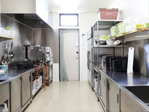 アルミ製のキッチンに、複数の炊飯器やガスコンロが設置されている様子